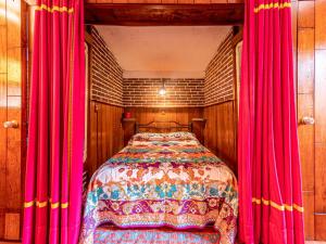 una camera da letto con letto e tende rosse di Dos Cabañas, Popocatépetl e Iztlaccíhuatl a Atlautla