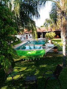 a swimming pool in a yard with chairs and trees at HOTEL SANTA MARIA in Asuncion