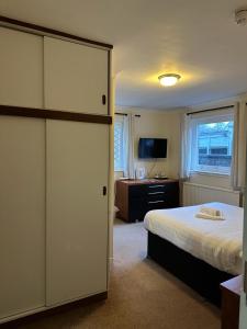 a bedroom with a bed and a desk and a television at The Kinross Salutation Hotel in Kinross