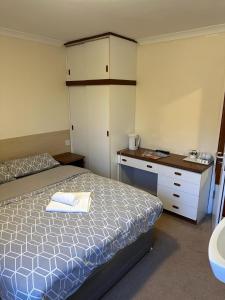 a small bedroom with a bed and a desk at The Kinross Salutation Hotel in Kinross