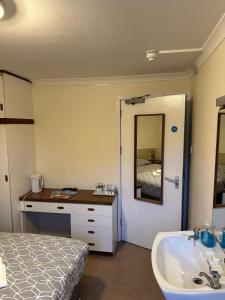 a bathroom with a bed and a sink and a tub at The Kinross Salutation Hotel in Kinross