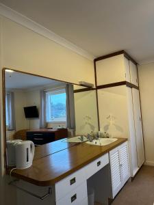 baño con 2 lavabos y espejo grande en The Kinross Salutation Hotel en Kinross