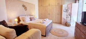 a room with a bed and a couch and a tv at Villa Angelo Porto Heli in Porto Heli