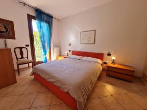 a bedroom with a bed and a chair and a window at Residenza La Corte in Castelnuovo del Garda