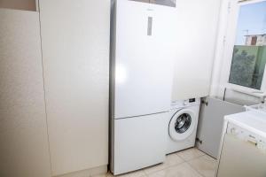 a white refrigerator in a kitchen with a washing machine at Seafront central Apt in Lavrio in Lávrion