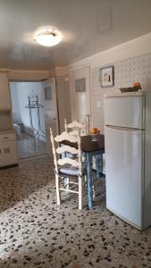 a kitchen with a dining room table and a refrigerator at Το σπιτάκι στον παραδοσιακό οικισμό Λειβαδίων Άνδρου in Vrakhnós