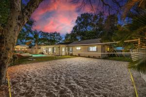 ein Haus mit einer Palme davor in der Unterkunft 5 mins to Honeymoon Island~Sand Volleyball~Firepit in Palm Harbor