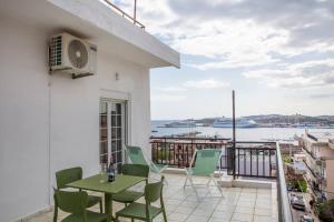 balkon ze stołem i krzesłami oraz widokiem na wodę w obiekcie Seafront central Apt in Lavrio w mieście Lawrio