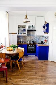 a kitchen with blue cabinets and a table with chairs at Przystanek w kolorach świata in Jelenia Góra