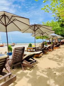 a row of tables and umbrellas on a beach at Pousada Capitão Thomaz in Jericoacoara +116 photos