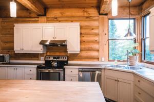 cocina con armarios blancos y fogones en Captivating view of Lake Superieur en Lac-Superieur