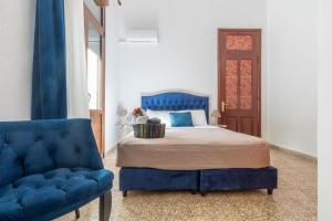 1 dormitorio con 1 cama azul y 1 silla azul en mascot traditional guest house en Rodas