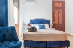 1 dormitorio con 1 cama azul y 1 silla azul en mascot traditional guest house en Rodas