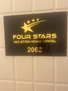 un cartel de cuatro estrellas de alquiler de casas de vacaciones en una pared en Four Stars Hostel, en Dubái
