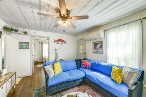 a blue couch in a living room with a ceiling fan at Cozy Texas Cottage Less Than 2 Mi to Rockport Beach! in Rockport