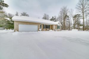 una casa con un garage nella neve di Cozy Mancelona Home Ski, Golf and Snowmobile! a Mancelona