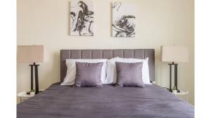 a bedroom with a large bed with two lamps at Stunning Nulu 1BR CozySuites 04 in Louisville