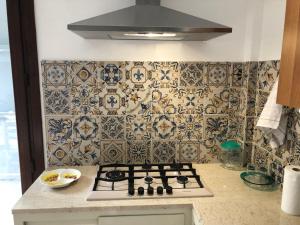 cocina con fogones y pared de azulejos en La casa di Desy&Giò, en Erice