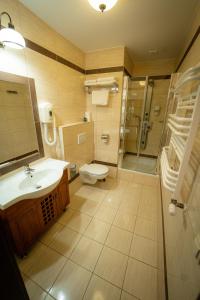 y baño con aseo, lavabo y ducha. en Hotel Górski, en Wolbórz