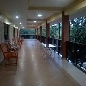 Großes Zimmer mit Stühlen, Tischen und großen Fenstern in der Unterkunft Pousada Paraíso das Orquídeas in Nova Santa Medianeira