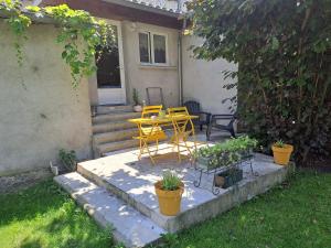 a patio with a table and chairs and plants at Gîte 3 "le Canal de Baza" aux Magnolias in Aubenas +23 photos
