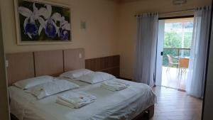 a bedroom with a bed with towels on it at Pousada Paraíso das Orquídeas in Nova Santa Medianeira