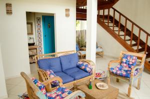 a living room with a blue couch and chairs at Quinta Brasilis Boutique Hotel Paraty in Paraty