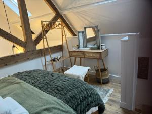 ein Schlafzimmer mit einem Bett und einem Waschtisch mit einem Spiegel in der Unterkunft The Old Dairy in Newbury