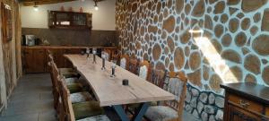 a long wooden table in a room with a stone wall at Pokoje Gościnne Skalnik - Agroturystyka- Różne pokoje in Kostrzyn nad Odrą