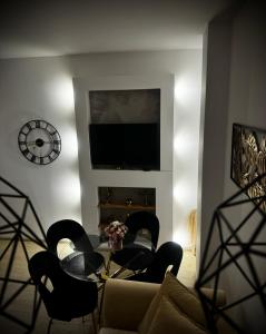 a living room with a couch and chairs and a television at Apartament Nowar in Nowa Ruda