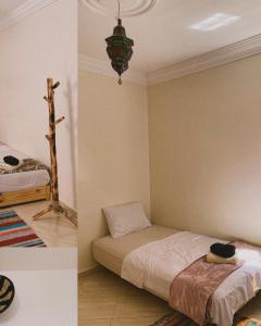 twee foto's van een slaapkamer met een bed en een kroonluchter bij CHILL SURFER HOSTEL in Tamraght Ouzdar