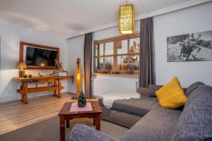 ein Wohnzimmer mit einem Sofa und einem Tisch in der Unterkunft Ferienwohnungen Sunnwies in Bodenmais