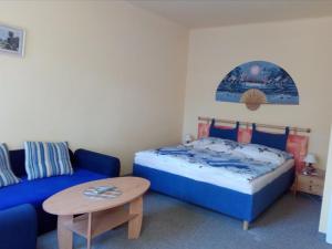 1 dormitorio con 1 cama azul y 1 sofá azul en Apartmány Sluníčko, en Nová Bystřice