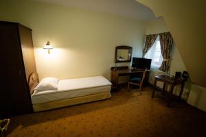 Hotel Górski في Wolbórz: غرفة نوم مع سرير ومكتب مع جهاز كمبيوتر