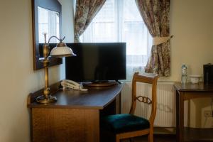 einen Schreibtisch mit Monitor, Lampe und Stuhl in der Unterkunft Hotel Górski in Wolbórz