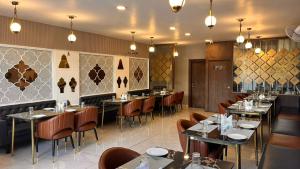 ein Restaurant mit Tischen und Stühlen in einem Zimmer in der Unterkunft Skymoon Hotel And Restaurant in Indore