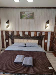 a bedroom with a bed with two towels on it at Кольорові подорожі 2 in Slavske
