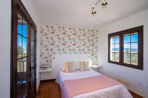 1 dormitorio con 1 cama y 2 ventanas en Villa Barrilla - La Vegueta Villas, en Tinajo