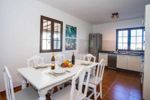 un comedor blanco con una mesa y sillas blancas en Villa Barrilla - La Vegueta Villas, en Tinajo