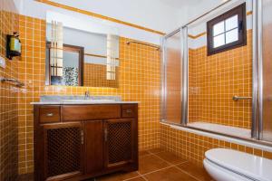 ein gelb gefliestes Bad mit einem Waschbecken und einem WC in der Unterkunft Villa Barrilla - La Vegueta Villas in Tinajo + 21 Fotos