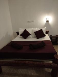 a bedroom with a large bed with black and white pillows at Eco Pavilion in Sigiriya