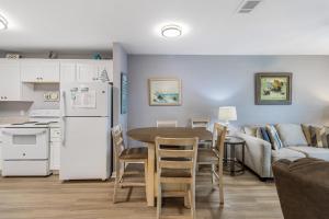a kitchen and living room with a table and a refrigerator at Plantation 4206 in Gulf Shores
