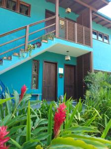Pousada Vila Guyrá في فلوريانوبوليس: البيت الأزرق مع الزهور أمامه