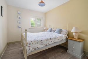 a bedroom with a white bed and a window at Elmcroft Holiday Annex in Gillingham