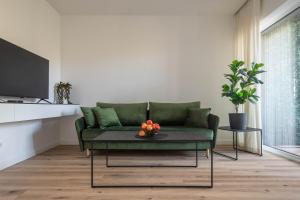 un soggiorno con divano verde e cesto di frutta di Melnragė II terasa a Klaipėda