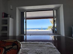 a room with an open door with a view of the ocean at Charlie Home - Heart of Sardinia in Costa Paradiso