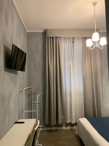 um quarto com uma cama, uma televisão e uma janela em Villa Giovanna Citylife Milano em Milão