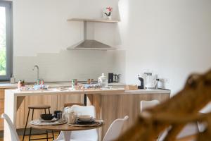 eine Küche mit einem Tisch und einer Theke mit einer Spüle in der Unterkunft Villa Essenza - Rooms and Breakfast in Albenga