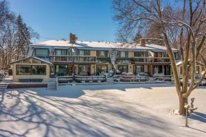 una casa grande con techo cubierto de nieve en Riverfront Champlin Townhome with Deck and Water View!, en Champlin