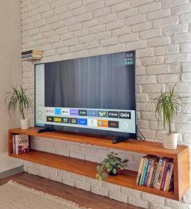 a flat screen tv sitting on a wooden shelf at Stylish Garden Retreat, Ultimate Relaxation in Antalya